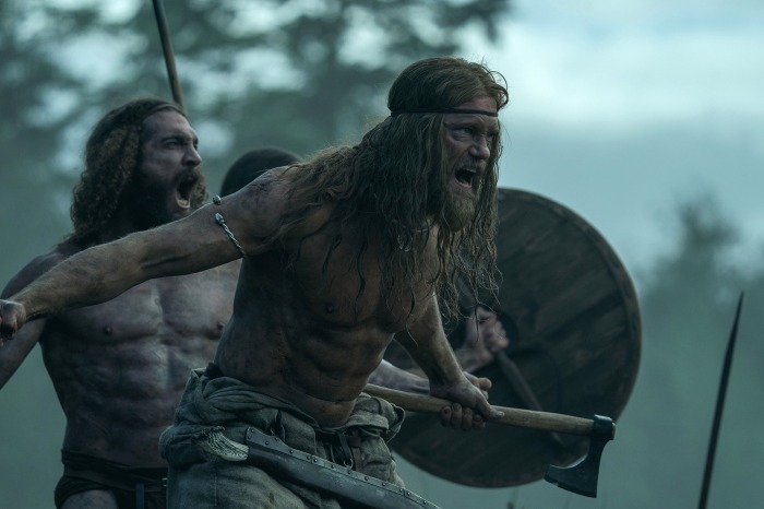 A shirtless Alexander Skårsgard doing battle as a Viking warrior in The Northman.